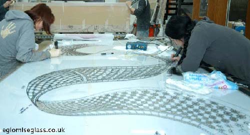 applying raised resin pattern on face of glass