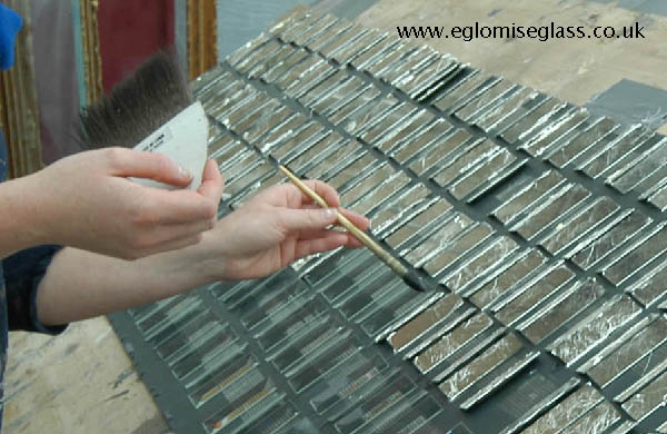 water gilding with silver leaf on the back of bevelled glass